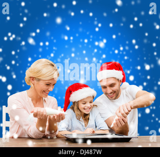 Happy Family im Santa Helfer Hüte machen cookies Stockfoto