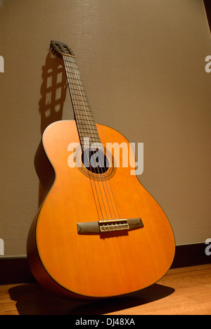 Eine klassische Gitarre an der Wand lehnen Stockfoto