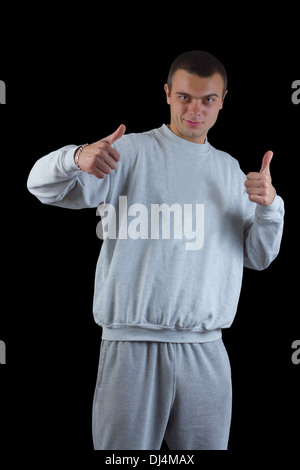 junger Kerl in einem Trainingsanzug auf schwarzem Hintergrund Stockfoto