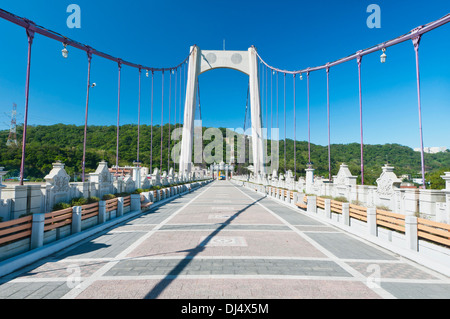 Ziegel-Fußgängerbrücke zum grünen Hügel Stockfoto