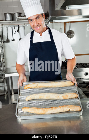 Männlich-Chef präsentiert gebackene Brote In Küche Stockfoto