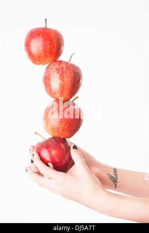 Frau Ausgleich vier rote Äpfel Stockfoto