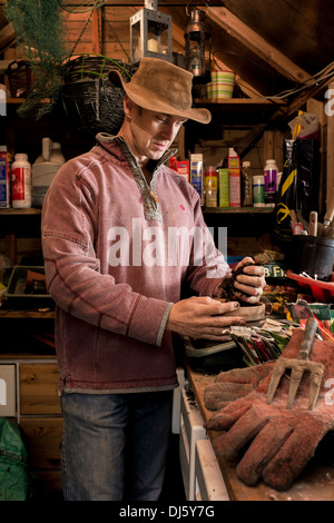 Mann arbeitet in einer Pottingbank in seinem Gartenhaus. Stockfoto