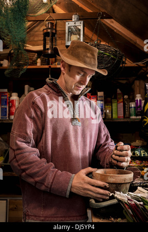 Mann arbeitet in einer Pottingbank in seinem Gartenhaus. Stockfoto