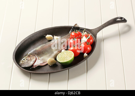 Frische Forellen und Gemüse auf Gusseisen Pfanne Stockfoto