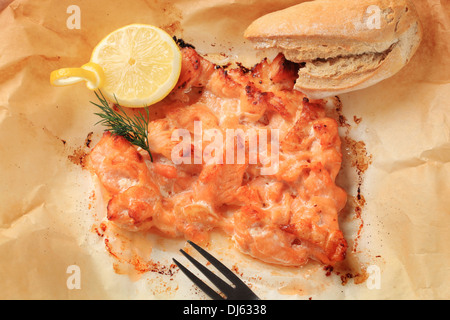 Lachs in Folie mit Zitrone und Brot Rollen Stockfoto