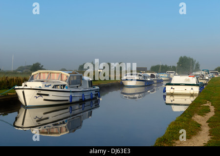 Sportboote im frühen Morgennebel und Sonnenschein auf dem Fluß Thurne, Thurne, Norfolk, England, United Kingdom, UK, Europa Stockfoto