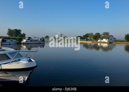 Freizeitboote und Windmühle im frühen Morgennebel und Sonnenschein auf dem Fluß Thurne, Thurne, Norfolk, England, UK, Europa Stockfoto