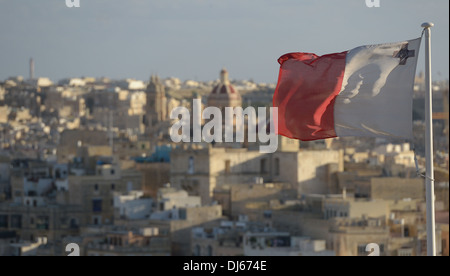 Flagge von Malta mit George Cross mit der alten Stadt Senglea im Hintergrund mit Blick auf den Grand Harbour von Valletta Stockfoto