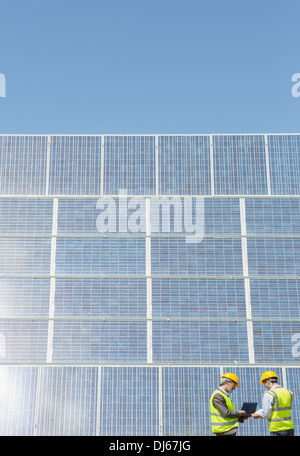 Arbeitnehmer, die Prüfung von Sonnenkollektoren in ländlichen Landschaft Stockfoto