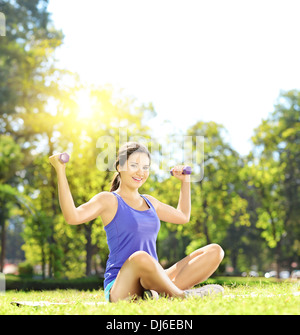 Junge Sportlerin in das Training mit Hanteln in einem Park Sportbekleidung Stockfoto