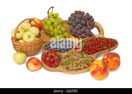 Stillleben mit Obst - Äpfel, Trauben, Himbeeren, Johannisbeeren, Pfirsiche, Blaubeeren in Holz Schalen und Korb Stockfoto