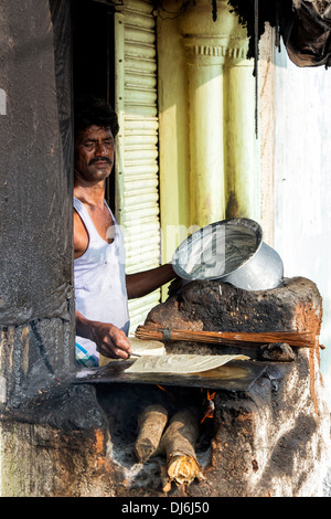 Indischer Mann Kochen Masala Dosa für Menschen in einem ländlichen Dorf. Andhra Pradesh, Indien Stockfoto