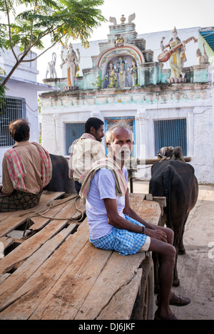 Südindische Männer auf einem Ochsenkarren vor einem hindu Tempel in einem indischen Dorf. Andhra Pradesh, Indien Stockfoto