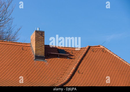 Fragment von Ziegeldächern gegen den blauen Himmel. Stockfoto