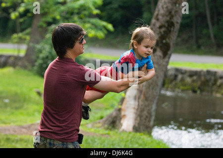 Vater spielt mit kleinen Sohn neben Bach im Frühjahr Mill State Park in Indiana Stockfoto