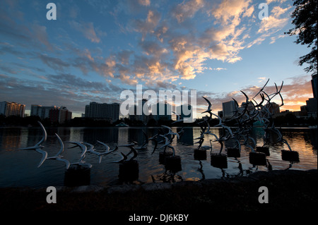 Siehe Art Orlando "Nehmen Sie Flight" des Künstlers Douwe Blumberg am Lake Eola Skulptur mit der Innenstadt von Orlando, Florida-Gebäuden. Stockfoto