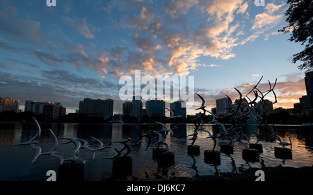 Siehe Art Orlando "Nehmen Sie Flight" des Künstlers Douwe Blumberg am Lake Eola Skulptur mit der Innenstadt von Orlando, Florida-Gebäuden. Stockfoto