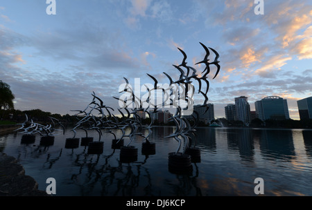 Siehe Art Orlando "Nehmen Sie Flight" des Künstlers Douwe Blumberg am Lake Eola Skulptur mit der Innenstadt von Orlando, Florida-Gebäuden. Stockfoto
