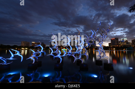 Siehe Art Orlando "Nehmen Sie Flight" des Künstlers Douwe Blumberg am Lake Eola Skulptur mit der Innenstadt von Orlando, Florida-Gebäuden. Stockfoto