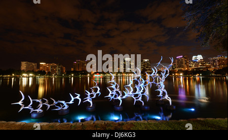 Siehe Art Orlando "Nehmen Sie Flight" des Künstlers Douwe Blumberg am Lake Eola Skulptur mit der Innenstadt von Orlando, Florida-Gebäuden. Stockfoto