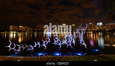 Siehe Art Orlando "Nehmen Sie Flight" des Künstlers Douwe Blumberg am Lake Eola Skulptur mit der Innenstadt von Orlando, Florida-Gebäuden. Stockfoto