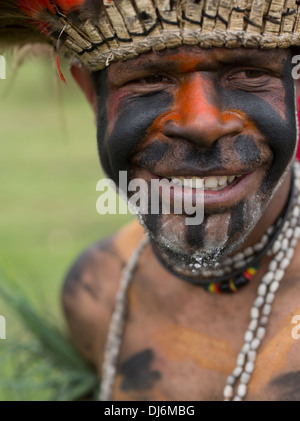 Mann mit bemaltem Gesicht lächelnd in Goroka Show Singsing, Papua-Neu-Guinea Stockfoto