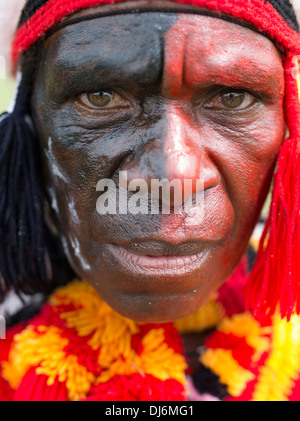 Tribal Mann mit rot und schwarz bemaltem Gesicht ¥ aus Goroka Region am Goroka Show Singsing Papua New Guinea Stockfoto