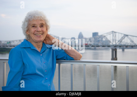 Ältere Frau posiert für Fotos auf der großen vier Fußgängerbrücke mit Louisville Kentucky im Hintergrund Stockfoto
