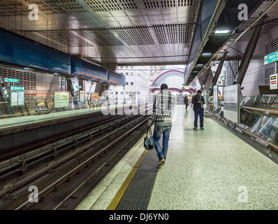 Passagiere warten auf Plattform des DLR (Dockland Light Railway) moderne Bahn Bahnhof - Heron Quays, London Stockfoto