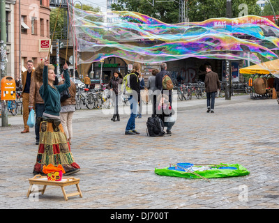 Weibliche Street Entertainer in bunten Rock produziert riesige Seifenblasen Hackescher Markt, Mitte, Berlin Stockfoto