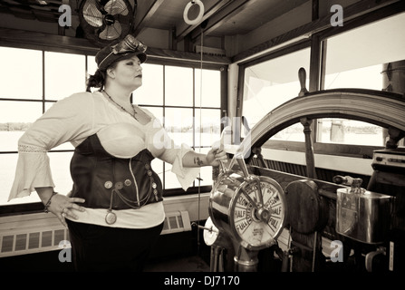 Junge Frau im Steampunk posiert im Steuerhaus auf dem Belle of Louisville Stockfoto