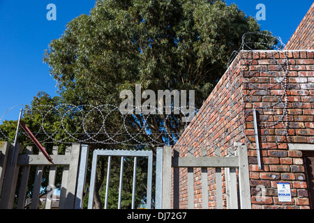 Südafrika, Cape Town. Stacheldraht und Metall-Spikes eine kleine Wohltätigkeitsorganisation Lager von unbefugten Zutritt zu schützen. Stockfoto