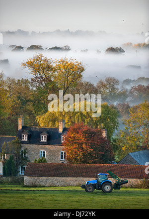 Ein Bauernhaus, umgeben von Herbst hochdeckend an einem nebligen Morgen in der Nähe von Wotton unter Rand in den Gloucestershire Cotswolds UK Stockfoto