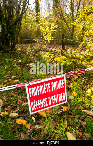Französisch Propriété Privée / Défence d'Entrer - Private Property / No Entry Zeichen auf Kunststoff Kette Barriere im Wald. Stockfoto