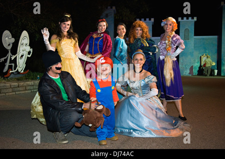 Kleinkind verkleidet sich als Mario mit seinem Vater und Disney Prinzessinnen an der Louisville Zoo-Halloween-Party in Louisville Kentucky Stockfoto