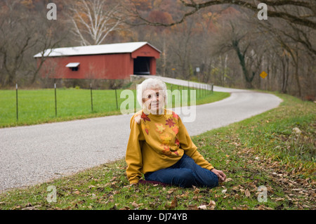 Neunzig Jahre alte Frau posiert für Fotos vor der Busching Covered Bridge in Ripley County, Indiana Stockfoto