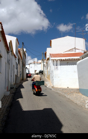 Ein motorradfahrer Reiten durch die weiß getünchten Häuser in Estombar eine Stadt und eine ehemalige Gemeinde im Kreis (concelho) Lagoa, Algarve, die südlichste Region Portugals Stockfoto