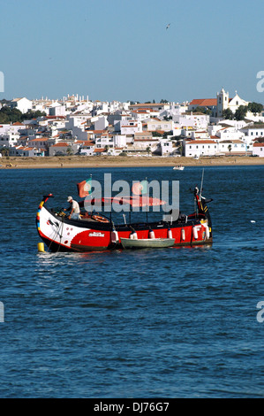 Ein Sightseeing-Boot, das entlang des Flusses Arade navigiert, mit Blick auf die Stadt Ferragudo im Hintergrund, an der westlichen Grenze der Gemeinde Lagoa in der Algarve, der südlichsten Region Portugals Stockfoto