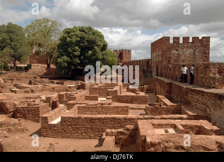 Besucher, die entlang von Wegen gehen, die einen nahen Blick auf bieten Die archäologischen Ausgrabungen in der maurischen Burg von Silves in Die Zivilpfarrei Silves an der Algarve, der südlichsten Region Portugal Stockfoto