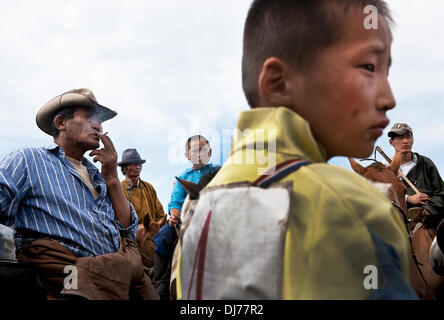 4. Juli 2012 - Ugtaal, Mongolei - junge Jockeys, Pferdebesitzer und Zuschauer vor einem Pferd Rennen während sammeln Naadam, das traditionelle mongolische fest der "drei männlichen Sportarten." Ländliche Naadams auftreten, über das ganze Land, Gebäude bis zu den nationalen Naadam, die in der Hauptstadt von Ulaanbaatar stattfindet. Mongolische pastorale Hirten bilden einen der größten restlichen nomadischen Kulturen der Welt. Seit Jahrtausenden haben sie in den Steppen lebten ihre Weidevieh auf den saftigen Wiesen. Aber heute ist ihre traditionelle Lebensweise gefährdet an mehreren Fronten. Neben einer sich rasch verändernden EG Stockfoto