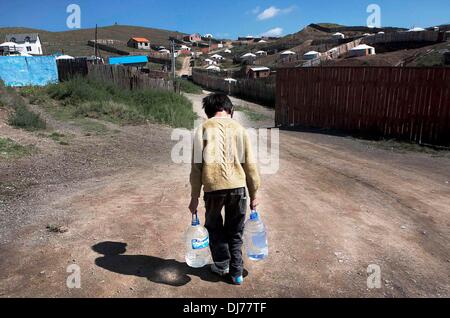 21. August 2012 - Ulaanbaatar, Mongolei - A mongolische Boy bringt Wasser in seine Heimat im Stadtteil Ger. 70 Prozent der Bevölkerung von Ulaanbaatar Gehäuse, diese Ger Camps haben keine sanitären Einrichtungen Dienstleistungen oder fließendes Wasser und haben eine hohe Arbeitslosigkeit, Alkoholismus und Kriminalität. Mongolische pastorale Hirten bilden einen der größten restlichen nomadischen Kulturen der Welt. Seit Jahrtausenden haben sie in den Steppen lebten ihre Weidevieh auf den saftigen Wiesen. Aber heute ist ihre traditionelle Lebensweise gefährdet an mehreren Fronten. Neben einer sich rasch wandelnden wirtschaftlichen Landschaft Klimawandel und Bodendegradierung Stockfoto