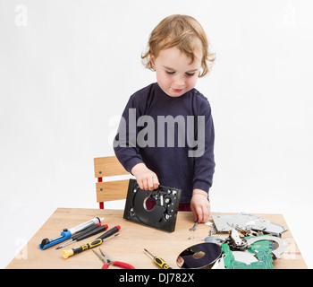 Vorschüler mit Computer-Teile auf Schreibtisch aus Holz. Studio in hellen grauen Hintergrund gedreht Stockfoto