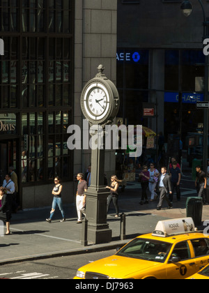 Bürgersteig Uhr, Taxi und Straßenszene, Fifth Avenue 43nd Street, NYC Stockfoto