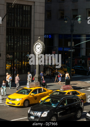 Bürgersteig Uhr, Taxis und Straßenszene, Fifth Avenue 43nd Street, NYC Stockfoto