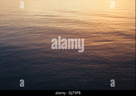 Kleine Wellen und Muster in das ruhige Meer während eines Sonnenuntergangs in Whitstable Seafront in Kent, UK Stockfoto