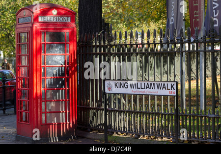 Eine traditionelle rote Telefonzelle gegen ein Eisen-Geländer in King William Walk, Greenwich, London Stockfoto