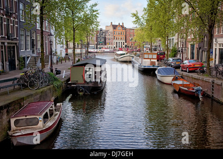 Hausboote, Boote und Häuser am Kanal in Amsterdam, die Niederlande. Stockfoto