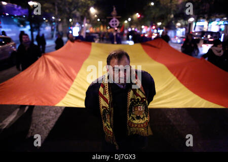 Madrid, Spanien. 23. November 2013. Ein Demonstrant mit einem Schal mit faschistischer Symbolik tragen mit Hilfe von 6 weitere Demonstranten eine riesige spanische Flagge sie nach el Valle de Los Caídos zu marschieren. Der Marsch findet statt von Madrid, das Tal der gefallenen, wo die Gräber von Spaniens Ex-Diktator General Francisco Franco und Primo de Rivera in seinen 77. Geburtstag liegen. Bildnachweis: Rodrigo Garcia/NurPhoto/ZUMAPRESS.com/Alamy Live-Nachrichten Stockfoto