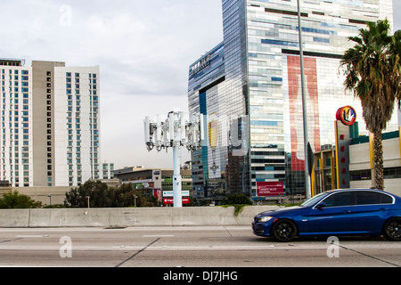 Ein Mobilfunkmast an der 110 Autobahn mit The Ritz Carlton Marriot Hotel im Hintergrund Stockfoto